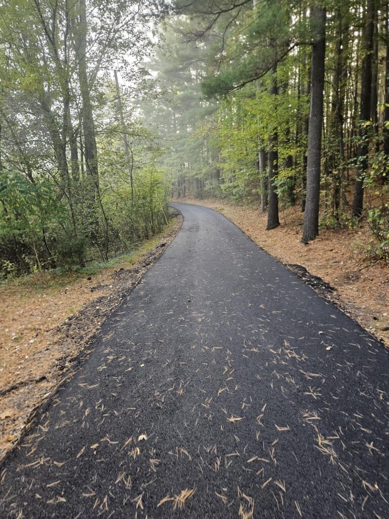 New asphalt driveway installed through wooded residential property