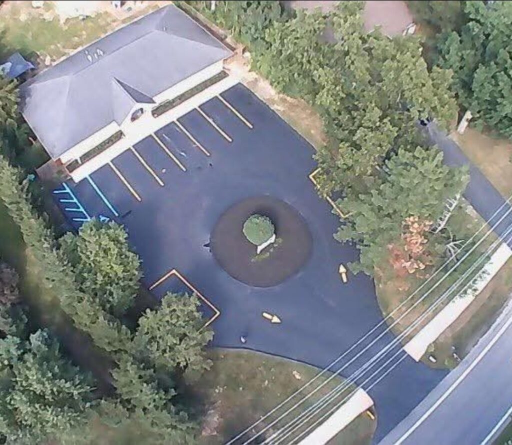 Commercial parking lot resurfacing with new asphalt and fresh striping.