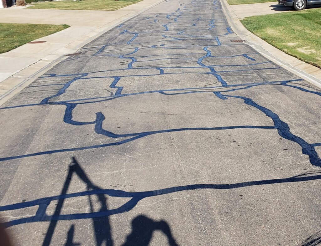 Parking lot crack sealing to repair asphalt pavement before sealcoating.