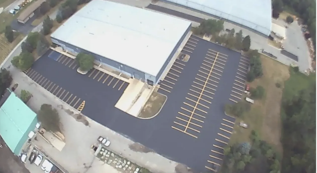 Newly paved commercial asphalt parking lot with fresh striping.