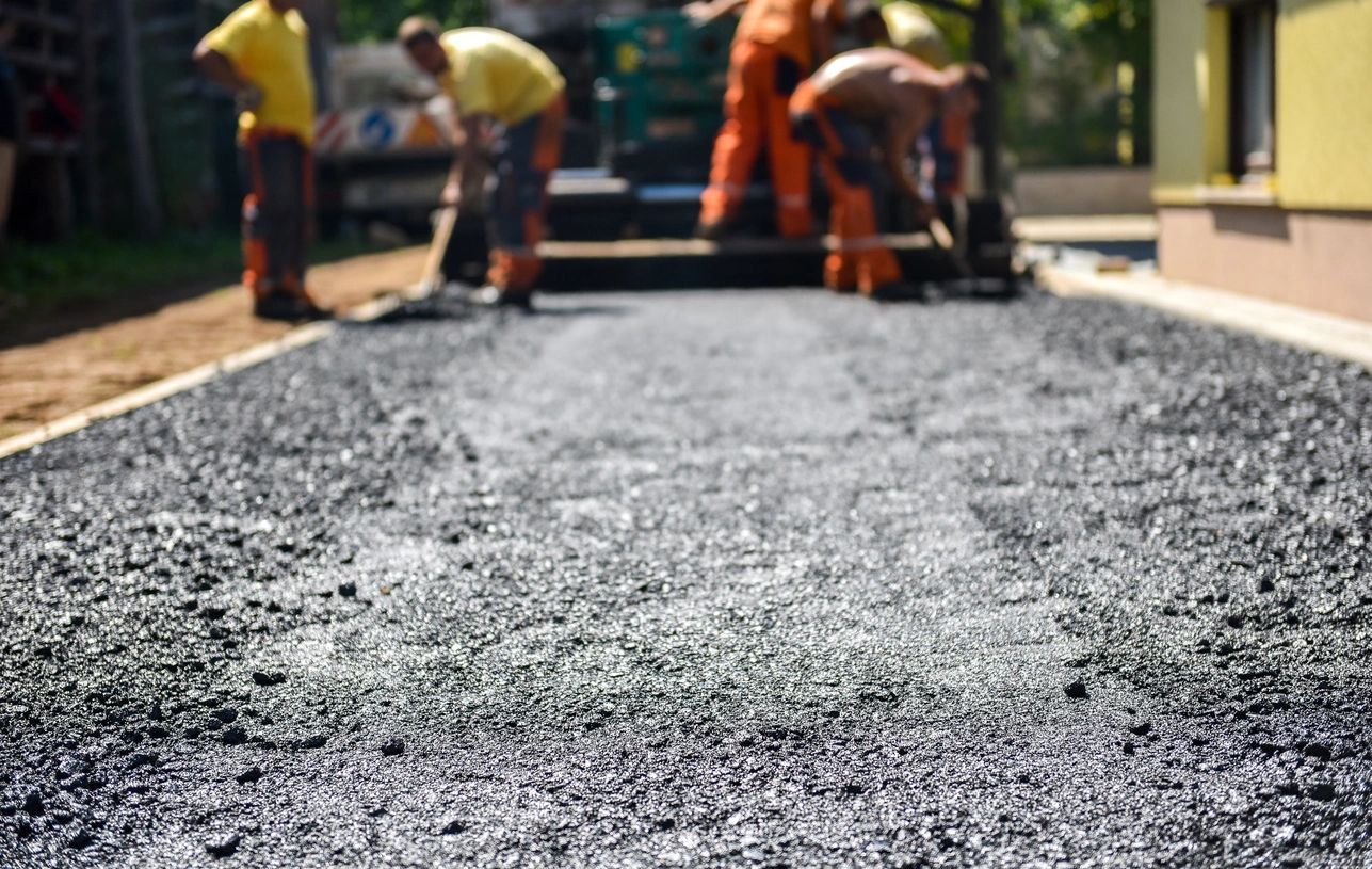 Asphalt repair and resurfacing work on pavement surface.